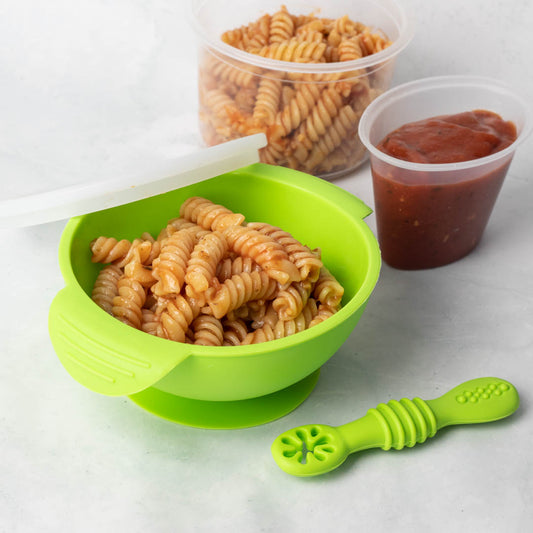 Green silicone suction bowl with pasta